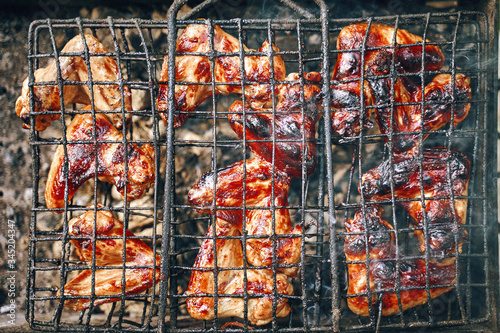 Delicious grilled meat chicken legs over the coals on a barbecue. Flat lay Top view