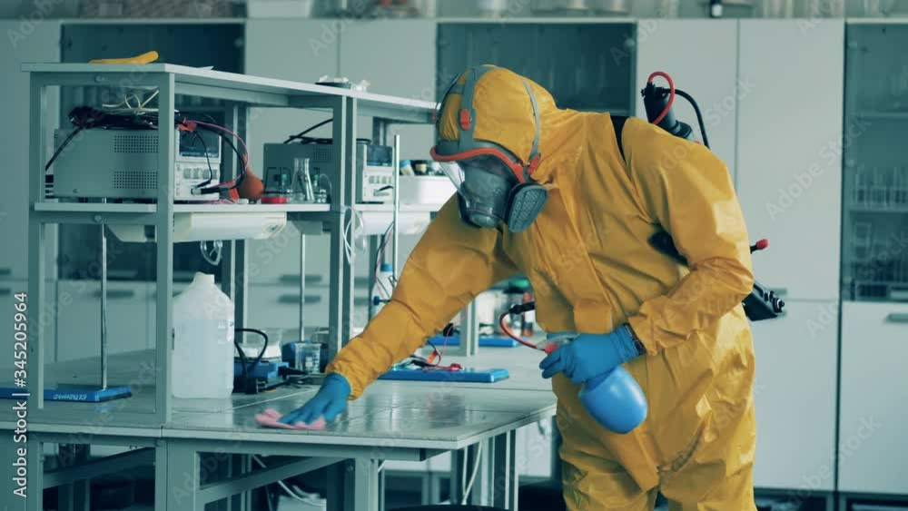 A sanitation worker wipes desks to kill virus. A sanitation worker wipes desks to kill virus.
