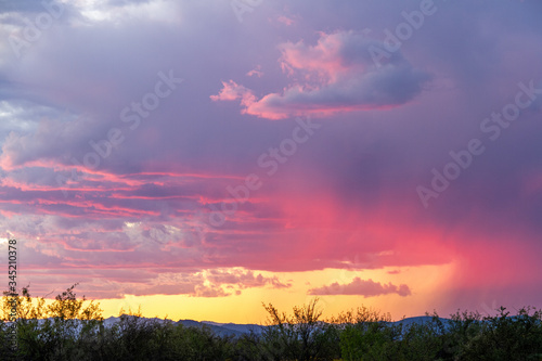 Distant rain in the Sonoran Desert of Arizona during sunset and blue skies.