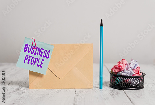 Writing note showing Business People. Business concept for People who work in business especially at an executive level Envelope sticky note marker paper balls container wooden background photo