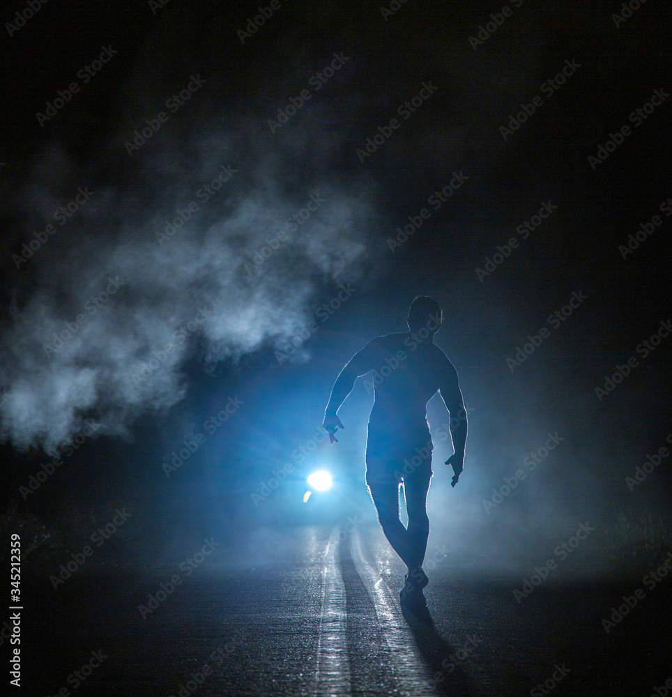 Mysterious figure in front of smoky car headlights Mysterious figure in front of smoky car headlights