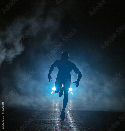 Mysterious figure in front of smoky car headlights