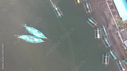 Prancak Perancak many traditional big and small Balinese boats panorama down and a small boat sailing photo