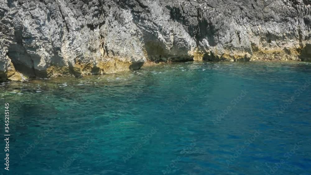 Tracking shot watching crystal clear turquoise sea waters and the rocky cliff. camera moves in the sea Tracking shot watching crystal clear turquoise sea waters and the rocky cliff. camera moves in the sea