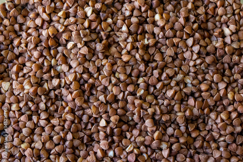 raw buckwheat, non-cooked buckwheat texture with grains of different colors in high quality © Veranika