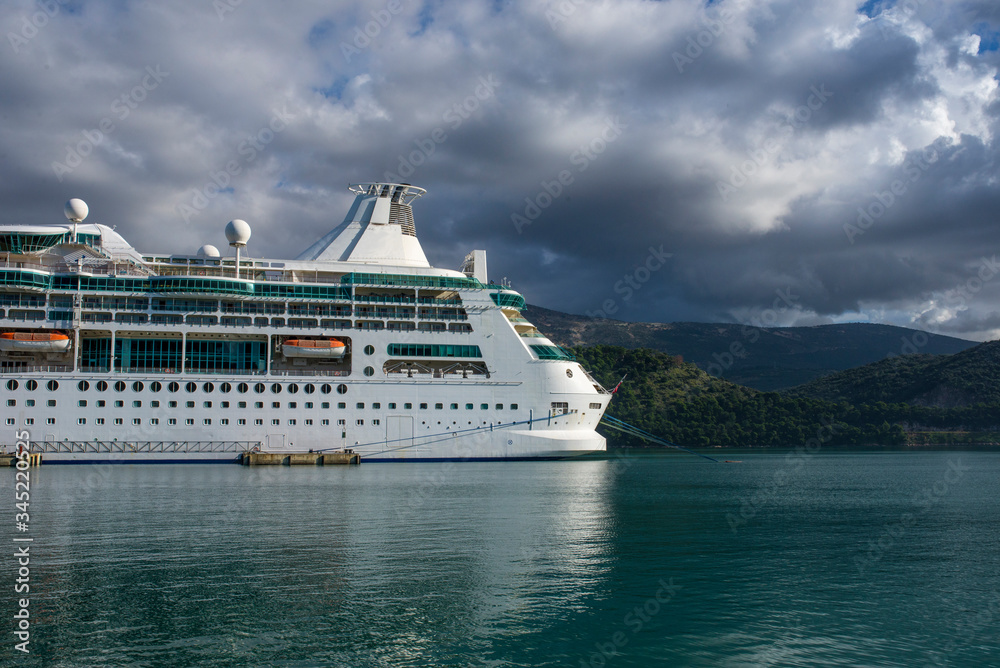 Unmarked bow of cruise ship on calm waters with storm clouds in the background.. 
