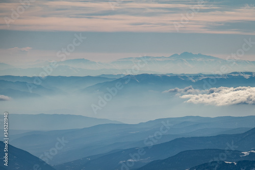 Caucasian mountains in layers in a beautiful foggy haze. Landscape