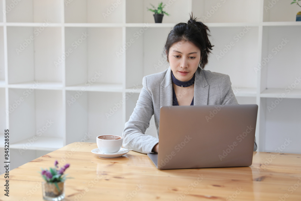 Young caucasian businesswoman working on laptop with hot coffee at wooden desk in lockdown. work from home. Young caucasian businesswoman working on laptop with hot coffee at wooden desk in lockdown. work from home.