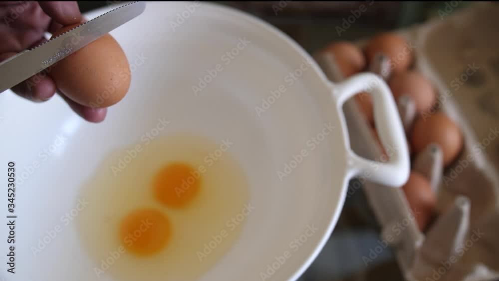 Ei wird aufgeschlagen um Eiweiß und Eigelb zu separieren und dieses in einer Schale verrührt um es in Teig oder Omlett zum Frühstück zu verarbeiten