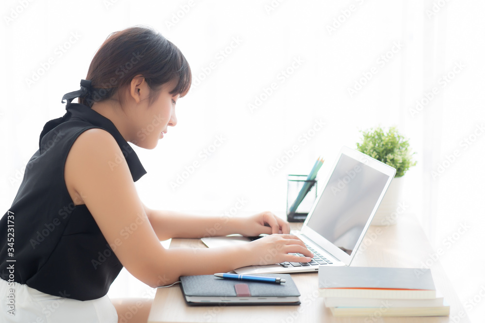 Beautiful freelance asian woman smiling working and typing on laptop computer at desk office with professional, girl using notebook checking email or social network, business and lifestyle concept. Beautiful freelance asian woman smiling working and typing on laptop computer at desk office with professional, girl using notebook checking email or social network, business and lifestyle concept.