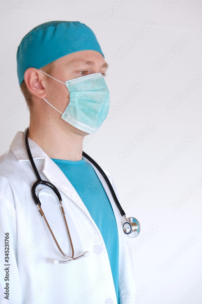 Doctor portrait.Medic's Day.A doctor in a protective mask, in a white coat and with a stethoscope on a white background.Medicine and health concept. Specialist in Medicine Doctor portrait.Medic's Day.A doctor in a protective mask, in a white coat and with a stethoscope on a white background.Medicine and health concept. Specialist in Medicine