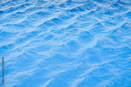 Water waves surface background. Aqua background texture. Abstract water ripples. Swimming pool at the resort. © Olly