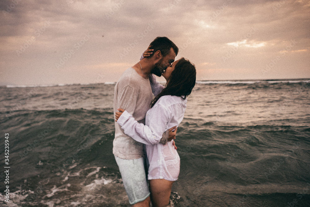 
Happy lovers have a cheerful vibes on sea beach at sunset 
