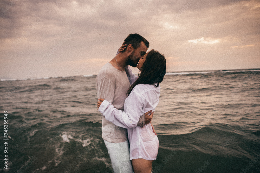 
Happy lovers have a cheerful vibes on sea beach at sunset 
