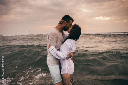  Happy lovers have a cheerful vibes on sea beach at sunset 