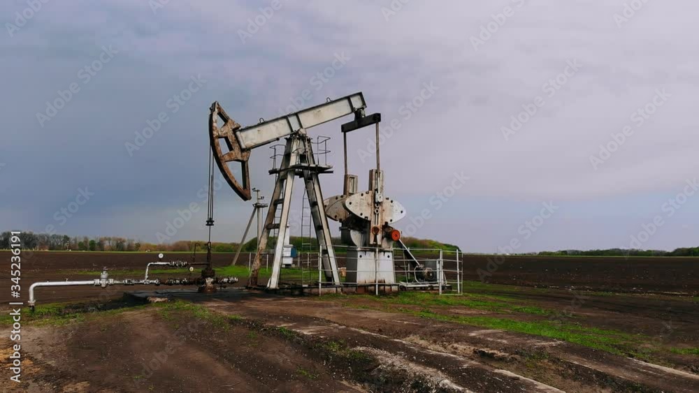 Working oil pumps against sun. Oil pump jack. oil rocking oil field Working oil pumps against sun. Oil pump jack. oil rocking oil field
