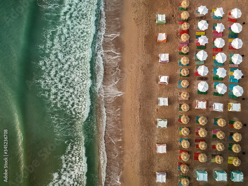 Aerial view of amazing beach with umbrellas and turquoise sea at sunrise. Black Sea at Vama Veche, Romania photo