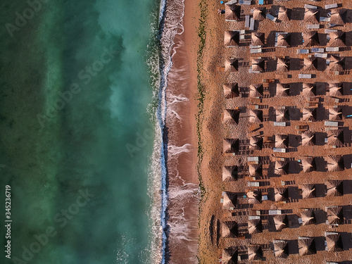 Aerial view of amazing beach with umbrellas and turquoise sea at sunrise. Black Sea at Vama Veche, Romania photo