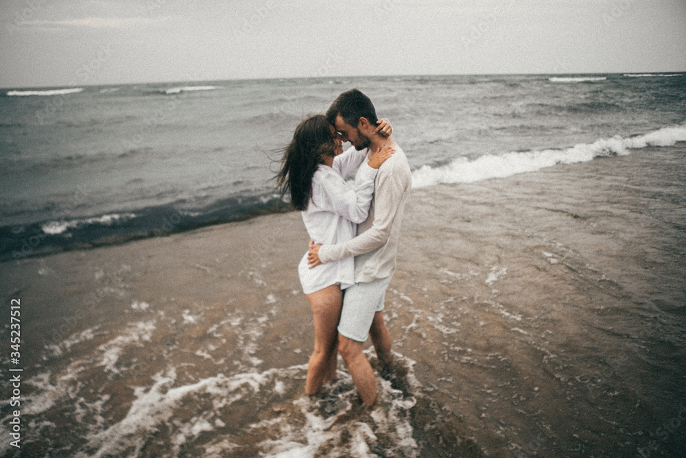 Happy lovers have a cheerful vibes on sea beach at sunset 