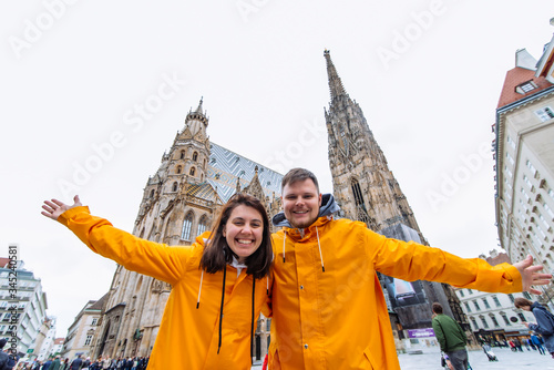 couple travelers in yellow raincoat in front of vienna cathedral church