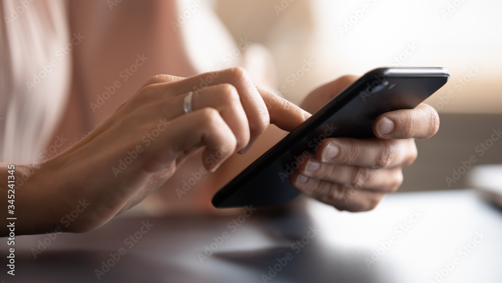 Close up female hands holding phone, typing on screen, young woman using smartphone, chatting in social network, writing message, browsing mobile device apps, blogger posting in blog Close up female hands holding phone, typing on screen, young woman using smartphone, chatting in social network, writing message, browsing mobile device apps, blogger posting in blog