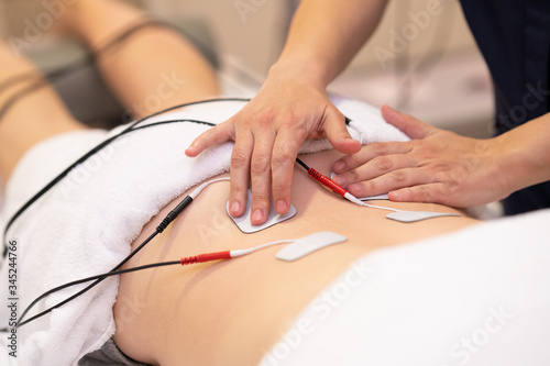 Photos Electro stimulation in physical therapy to a young woman