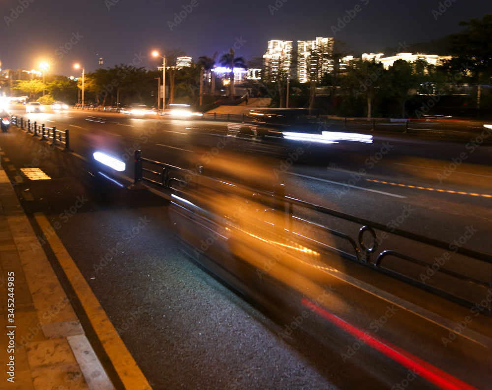 Cars on the road in the city in motion at night.