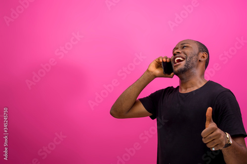 young black happy man using his smartphone and giving thumbs up © Courage