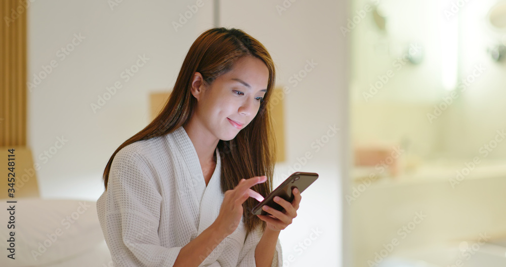 Woman uses smart phone on bed at night Woman uses smart phone on bed at night
