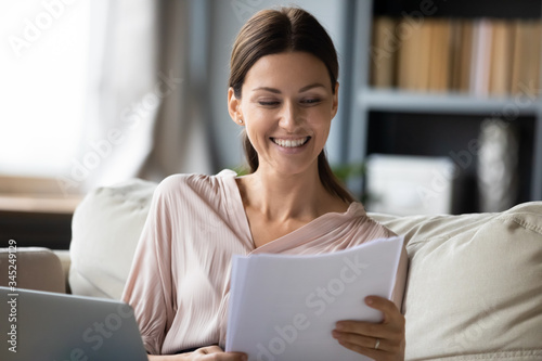 Canvas-taulu Smiling woman reading good news in paper letter close up, happy young female che