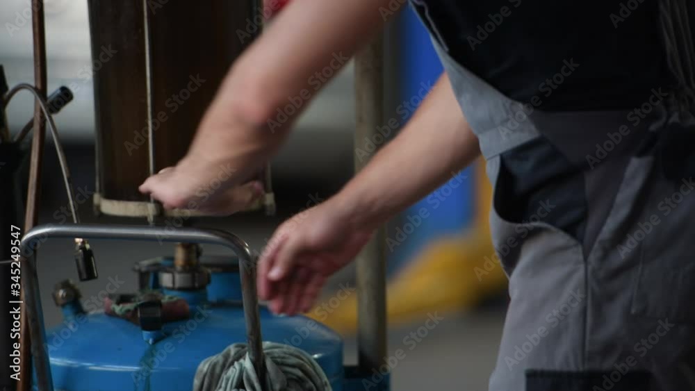 Ready for the work. Male mechanic use special device to repair broken automobile in garage. Ready for the work. Male mechanic use special device to repair broken automobile in garage.