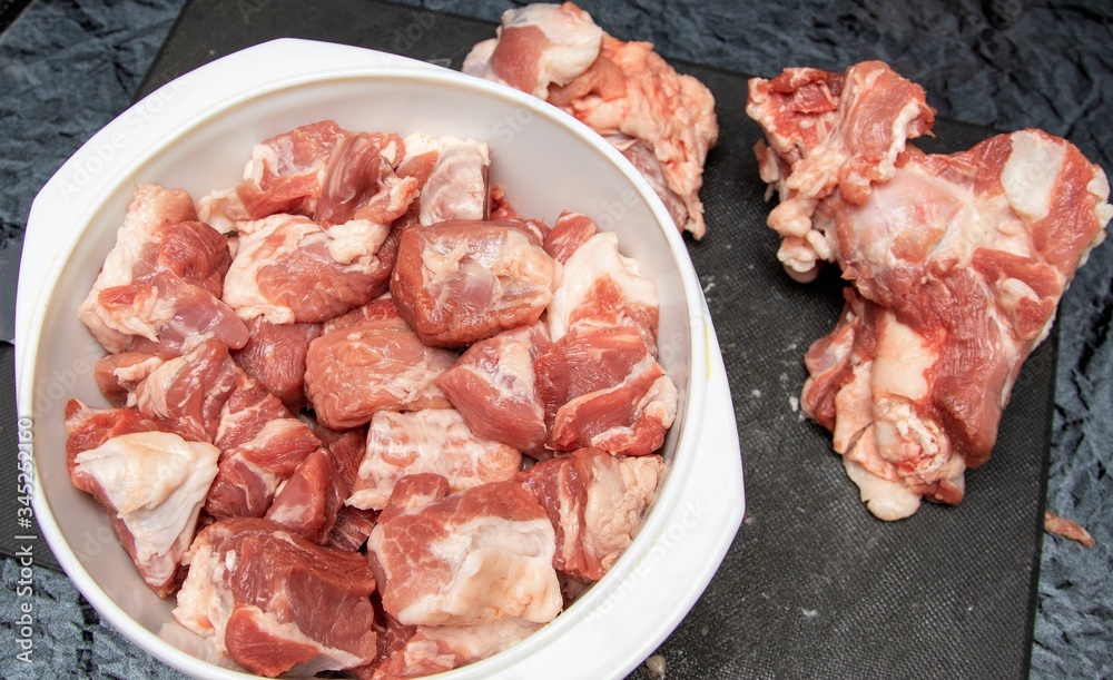 A piece of pork meat on the table, sliced for cooking.