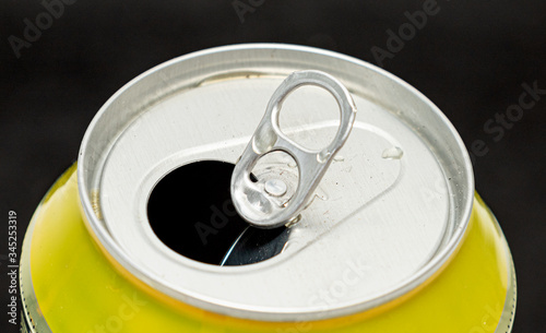Open beer can on a black background, close-up.