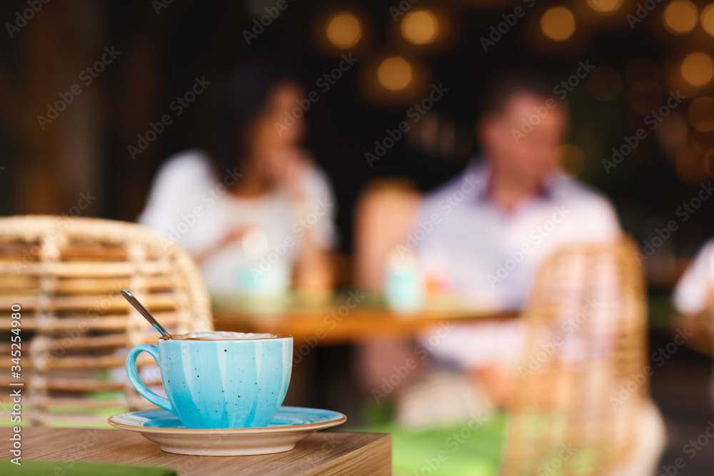 Morning coffee on the cozy cafe terrace. A Cup of coffee is on a table in an outdoor cafe