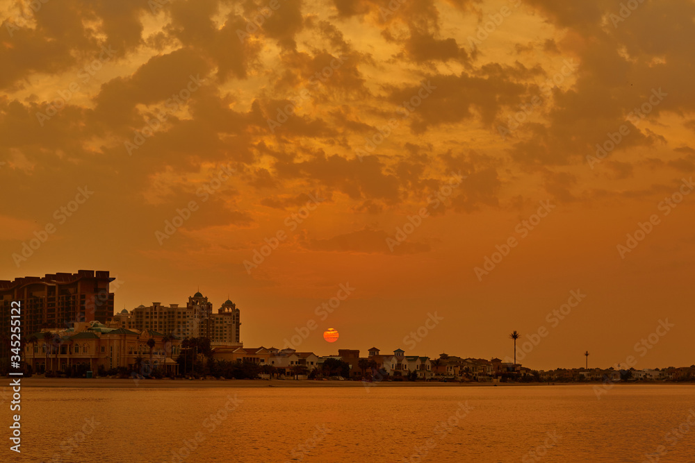 Beautiful orange sunset on the sea. Sunset over the city on the coast, romantic vacation