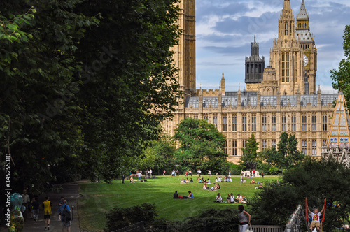 Photography People have a rest in a green meadow in a park near the parliament building in L