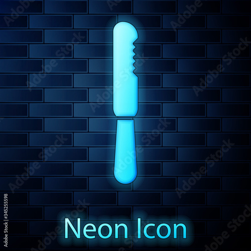 Glowing neon Disposable plastic knife icon isolated on brick wall background.  Vector Illustration