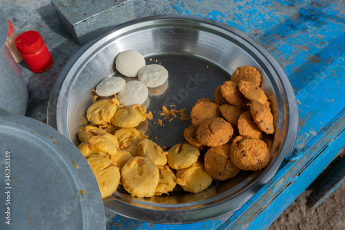 Piiyaji, bara, aloo chop etc, are being sold by cart puller called thelawalla , street foods of Odisha. photo