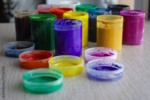 jars of gouache in different colors are on the table