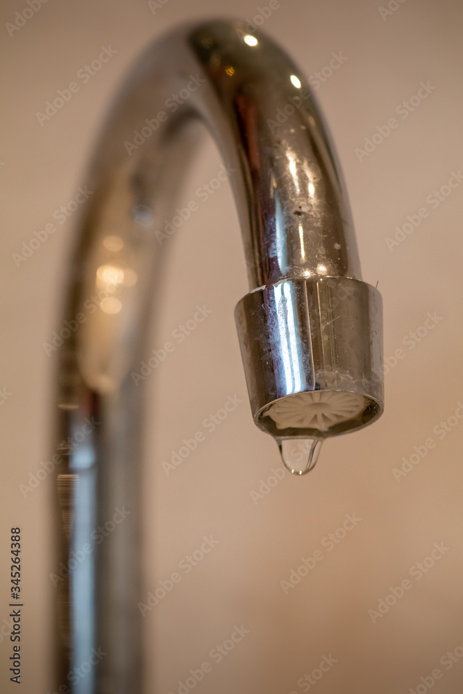 Dripping chrome tap letting water leak out Dripping chrome tap letting water leak out