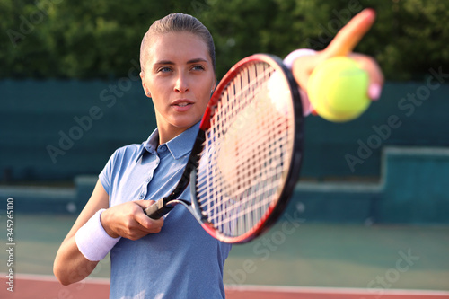 Beautiful tennis player serving the ball on the tennis court.