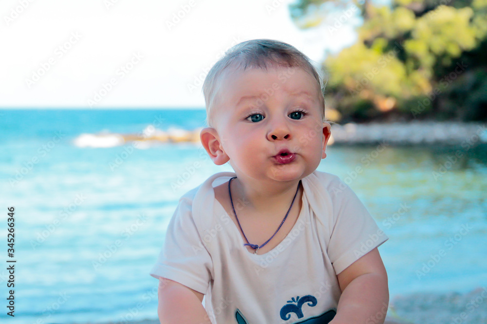 Cute surprised amazed kid baby boy at the sea background. Summer vacation. happy kid playing on beach. Cute surprised amazed kid baby boy at the sea background. Summer vacation. happy kid playing on beach.