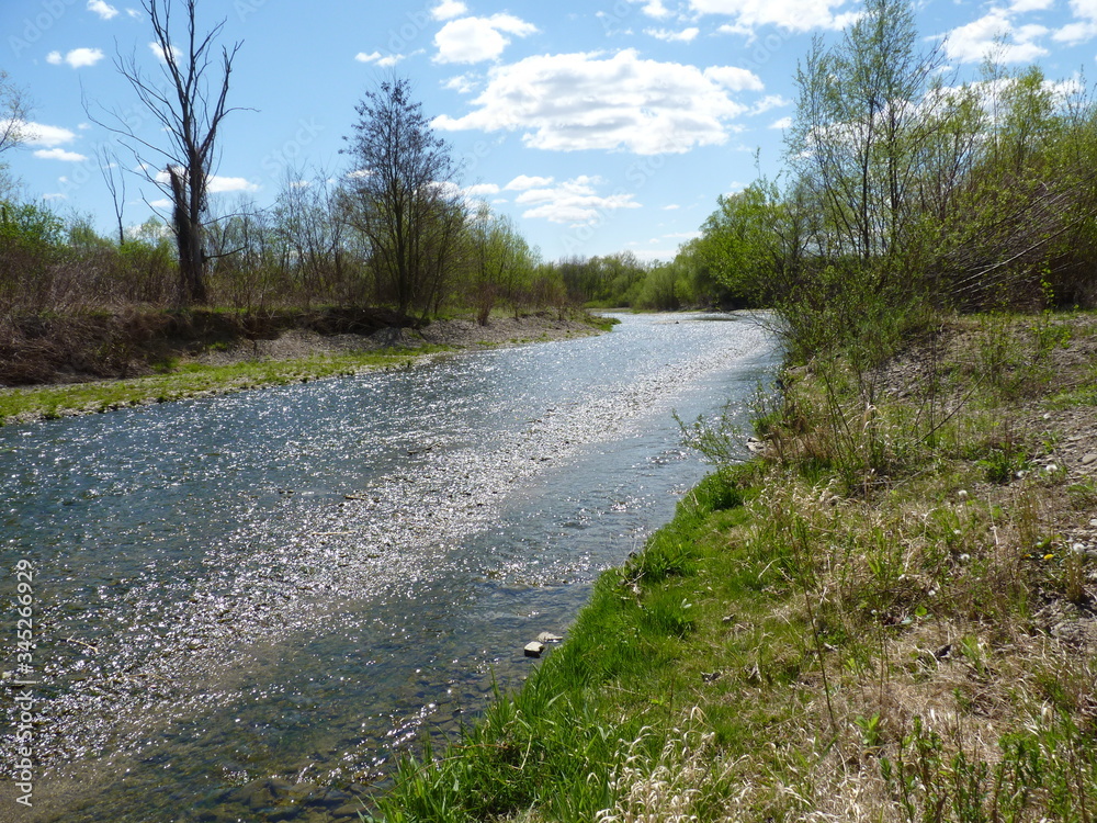 River stream on a lovely spring sunny day with blue sky in the background River stream on a lovely spring sunny day with blue sky in the background