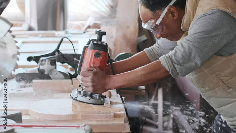 Electric milling cutter in the hands of a worker in a workshop. Starting a business. Craftsman