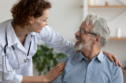 Wallpaper Mural Caring female doctor embracing helping happy senior male disabled patient at home medical care visit. Smiling physician talking with elder client. Eldercare, medicare, older people healthcare concept Torontodigital.ca