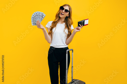 Bild auf Leinwand Traveller a woman in sunglasses holds tickets, passport and cash dollar bills wh