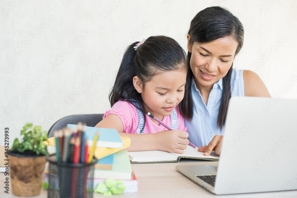 asia girl student online learning study online video call teacher. social distance during quarantine, self-isolation, online education concept, homeschool, cute girl with mother doing homework at home asia girl student online learning study online video call teacher. social distance during quarantine, self-isolation, online education concept, homeschool, cute girl with mother doing homework at home