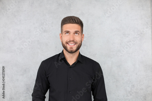 Portrait of happy fashionable handsome man in black shirt looking at camera
