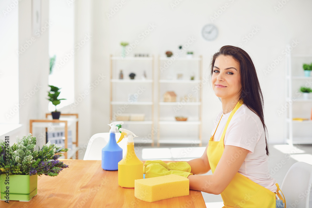 Happy young woman cleans the room in the house. Girl wash in gloves while sitting on the floor smiling joyful. Happy young woman cleans the room in the house. Girl wash in gloves while sitting on the floor smiling joyful.