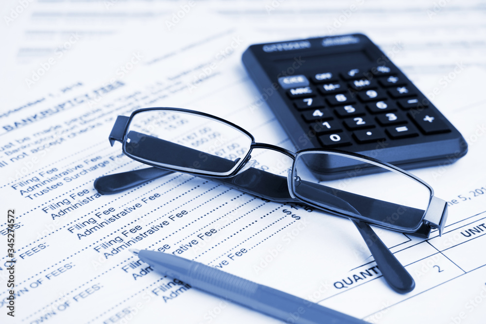 Bankruptcy concept. Close-up pen, calculator and glasses at financial report. Bankruptcy concept. Close-up pen, calculator and glasses at financial report.